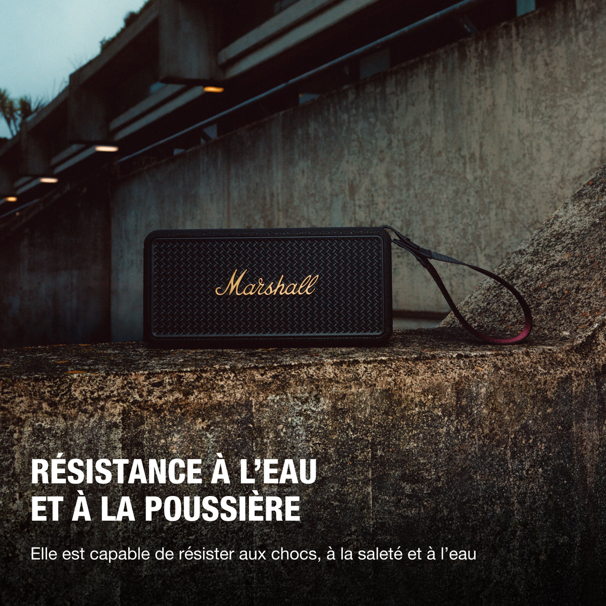 Marshall – Middleton II - Altavoz Portátil - Black & Brass, altavoz negro apoyado en un muro de piedra, con texto