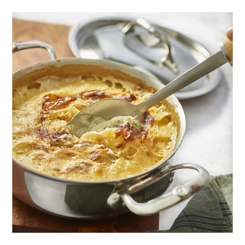 De Buyer – Meerlagige Hapjesspan - Rvs - Zilver, een goudbruine gratin dauphinois in een rvs pan, met een lepel