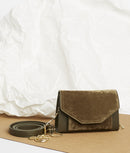 Pochette en velours textile taupe, munie d'une ceinture amovible en cuir pour la passer à la taille, et d'une chaîne dorée pour tout porté épaule. Le Papillon Velvet, par la maroquinerie PÖ&ME à Paris.