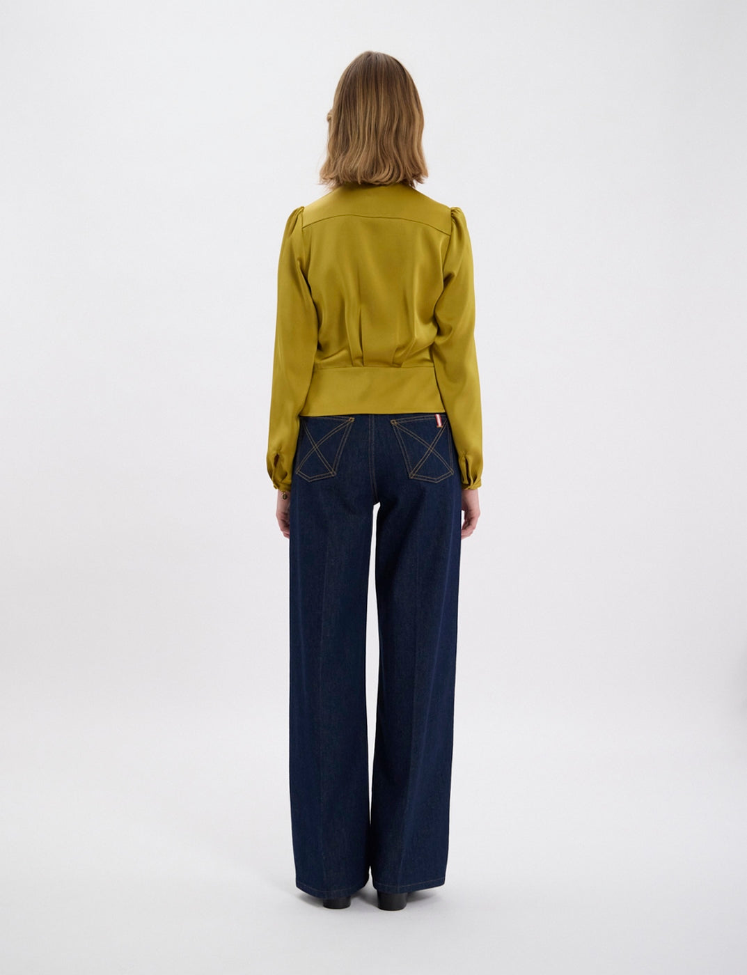 Ines De La Fressange – Top Emeline - Senape, modella di spalle con camicia giallo senape e jeans blu