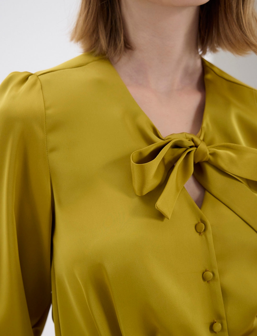 Ines De La Fressange – Top Emeline - Senape, camicetta satinata giallo senape con colletto lavallière, indossata da una modella