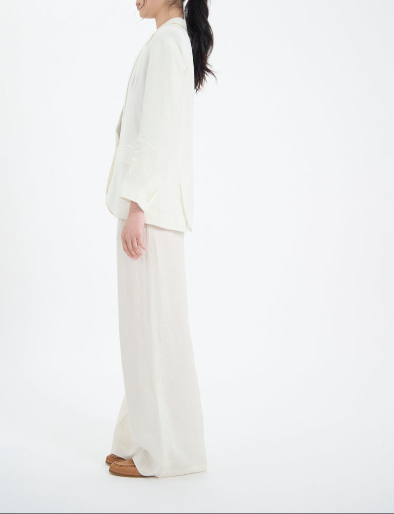 Ines De La Fressange – Giacca Bruna - Bianco, modella di profilo con completo blazer e pantaloni fluidi crema