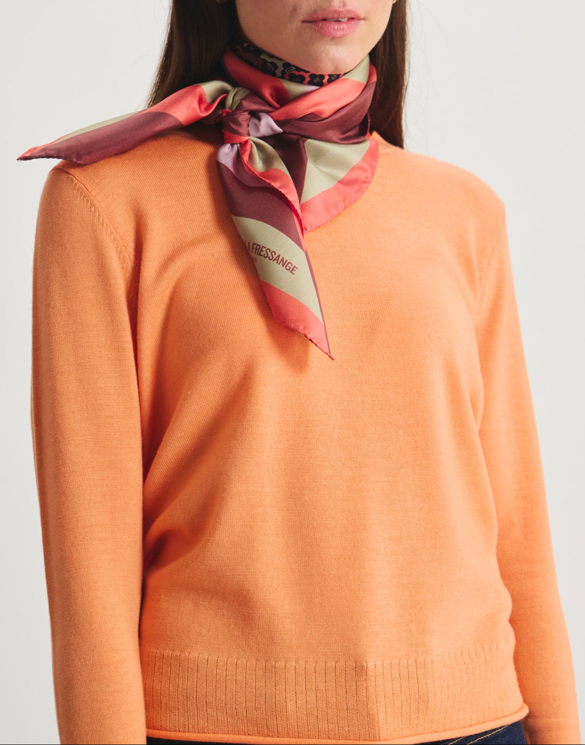 Ines De La Fressange – Tuch Lewis - Rosa, Model von vorne in einem orangefarbenen Pullover und einem bunten Seidentuch
