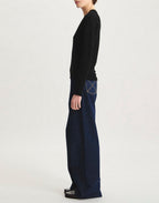 Ines De La Fressange – Pullover Morcant - Noir, weibliches Model im Profil mit schwarzem Pullover und weiter Jeans
