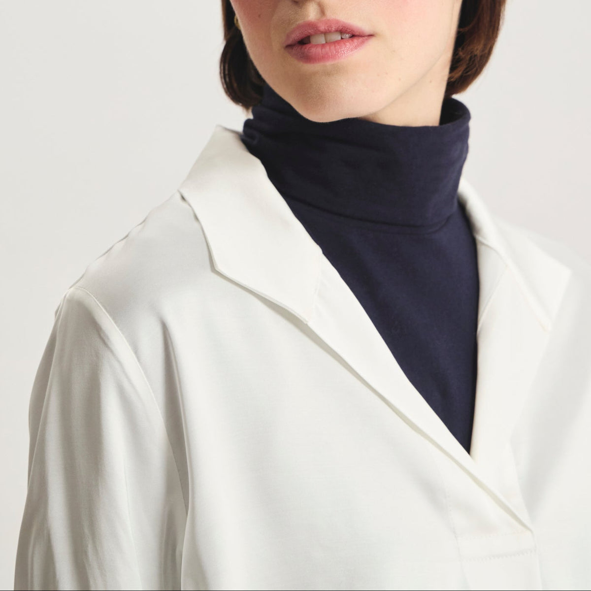 Ines De La Fressange – Camiseta Noa - Blanc, modelo mujer con jersey de cuello alto azul marino y camisa blanca