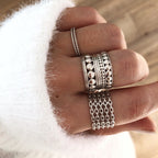 Instants Plaisirs – Bague "Louise" Argent, main avec plusieurs bagues en argent, pull blanc en maille