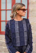 A cropped cut and fringes, nothing better as a piece that stands out from the crowd with the Anatole top with navy fringes. 