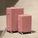 Set of two GYL Intemporelle rose gold rigid suitcases, cabin and hold sizes, placed on concrete floor. #color_rose gold