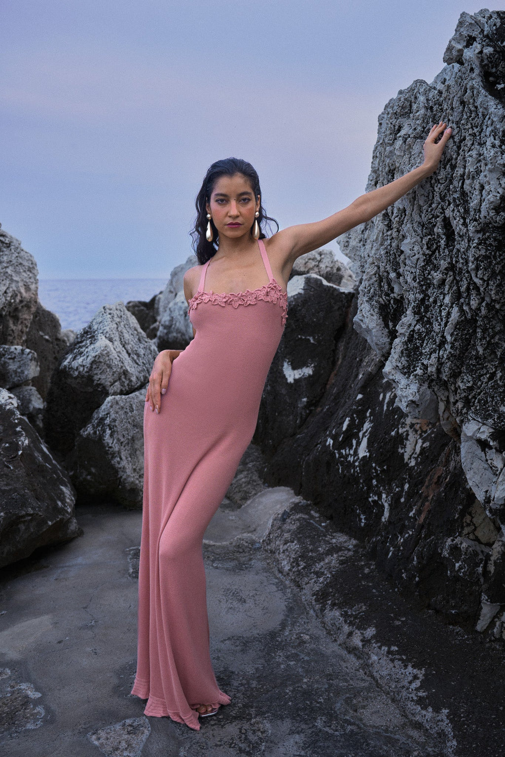 Vestido de punto con flores de ganchillo – Rosa, de la marca parisina Phème Paris, diseñado en París, con flores tejidas a ganchillo a mano, fotografiado en la costa del sur de Francia, silueta fluida ideal para vacaciones y ceremonias estivales.