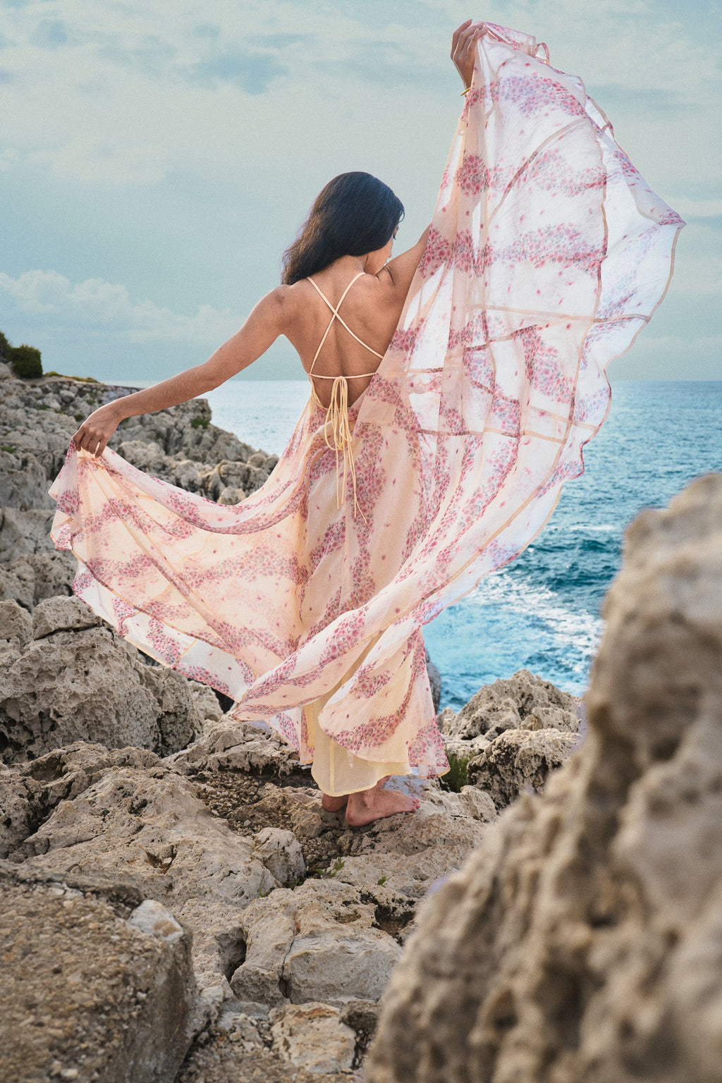 Vestido fluido de espalda descubierta en gasa beige y rosa con estampado de inspiración asiática de la marca parisina Phème Paris, fotografiado en la costa del sur de Francia, ideal para vacaciones, ceremonias de verano y bodas de destino.