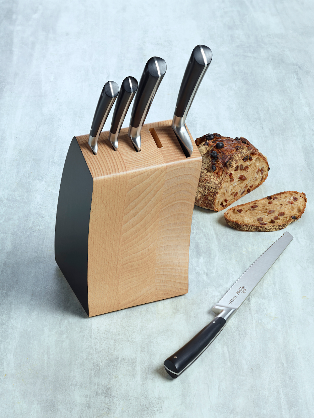 De Buyer – Unbestückter Messerblock + 6 Aussparungen für Steakmesser – Gummibaum – Holz, ein Messerblock aus Holz mit einem Brot und einem Brotmesser