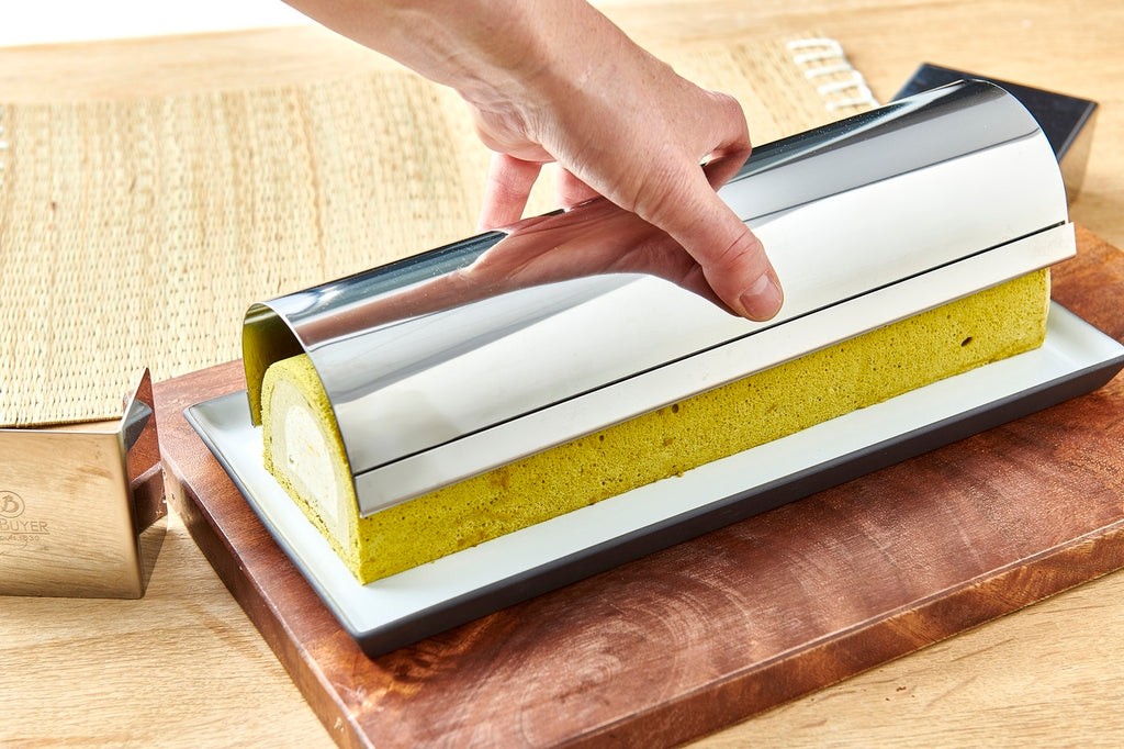 De Buyer – Gouttière À Bûche Ronde Démontable - Inox - Argent, gâteau roulé au thé matcha sur un plat blanc, sous un couvercle en inox