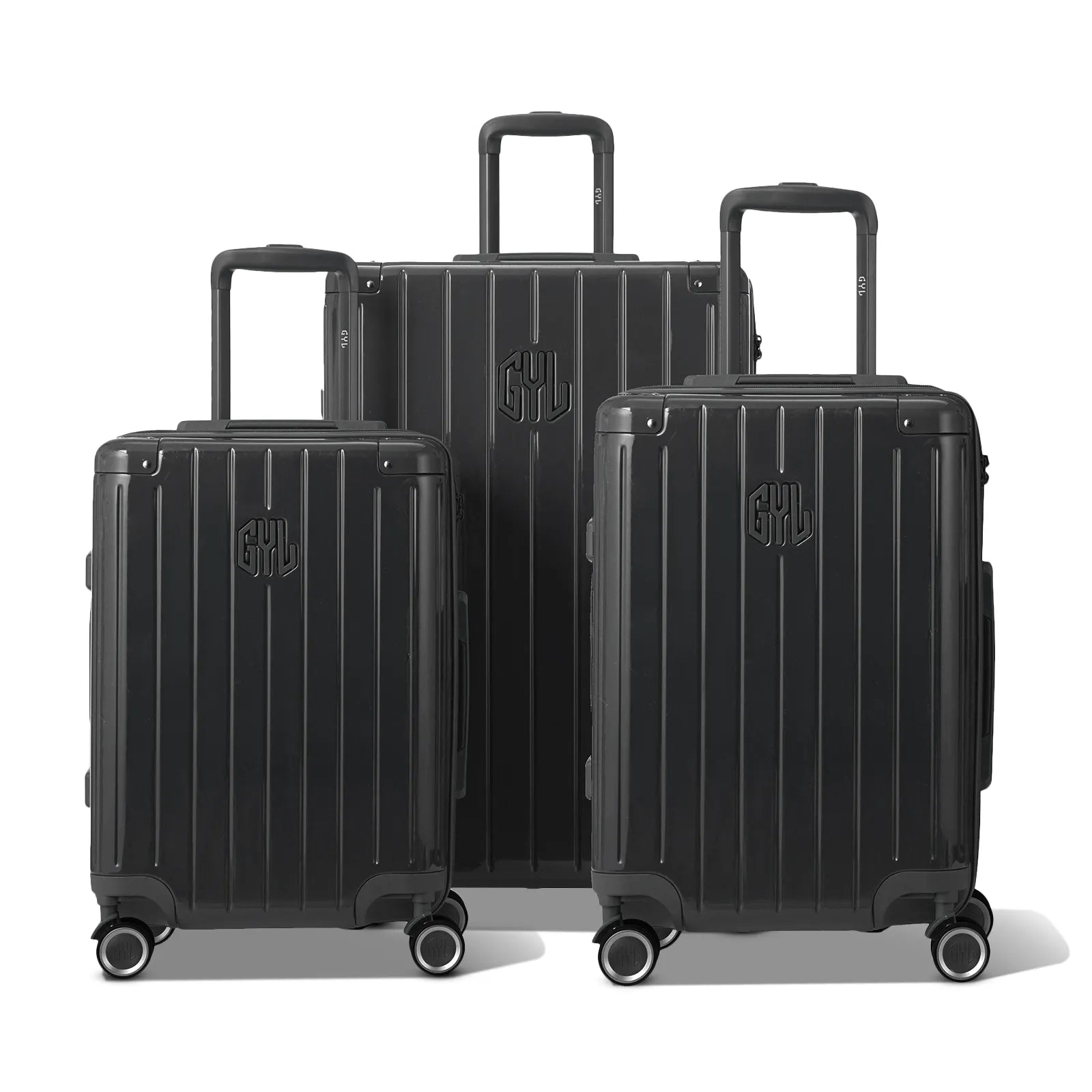 Trois valises rigides GYL Intemporelle gris foncé, format cabine et soute, avec poignée trolley déployée.  #couleur_gris foncé