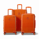 Trois valises rigides GYL Intemporelle orange, format cabine et soute, avec poignée trolley déployée.  #couleur_orange