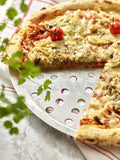 De Buyer – Rund perforerad bakplåt – Aluminium – Grå, pizza med körsbärstomater och örter på en aluminiumtallrik