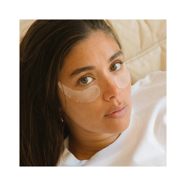 Woman wearing collagen eye patches to reduce dark circles and bags under the eyes