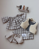 Tenue pour poupée Philéas - tenue garçon composée d'un short en lin beige, d'une blouse en voile de coton à carreaux avec un fil en lurex argent, un gilet de berger réversible - un coté fausse fourrure mouton et un côté lainage chevrons ainsi que d'une coiffe d'indien avec des plumes de cuir - Collection automne/hiver 2020 La manufacture moutarde à retrouver sur amaetc.com, concept store eco friendly pour bébés, enfants et toute la famille