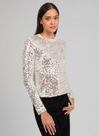 An'ge – T-Shirt Abela Ecru, mannequin portant un haut à sequins argentés et un pantalon noir