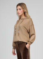 An'ge – Sweat Anika Camel, mannequin portant un sweat-shirt à capuche beige et un pantalon marron