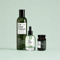 Lazartigue – Hereditary Anti-Hair Loss Routine, three green and black cosmetic bottles on a light green background