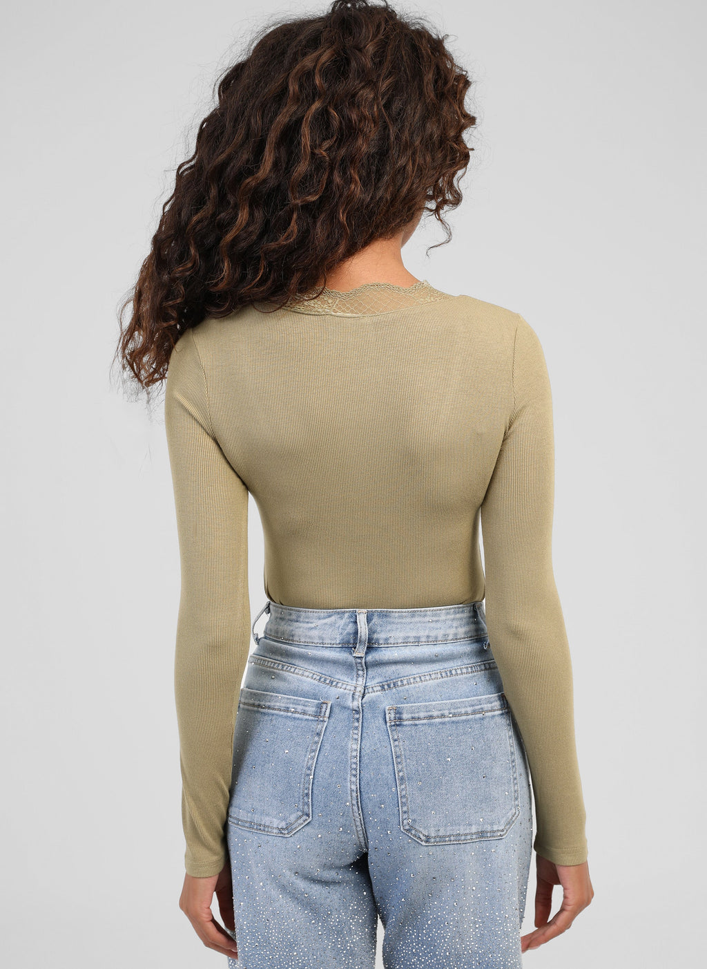 An'ge – T-shirt Asturial Lindegroen, model van de achterkant in een kakigroene top en een blauwe jeans
