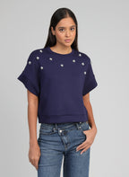 An'ge – Sweat Atika Marine, mannequin portant un pull bleu marine à manches courtes et clous argentés