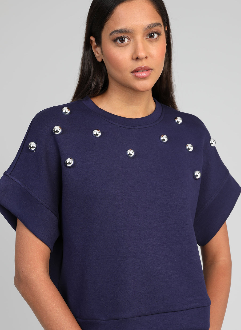 An'ge – Sweat Atika Marine, mannequin portant un sweat-shirt bleu marine avec des perles argentées