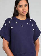 An'ge – Sweat Atika Marine, mannequin portant un sweat-shirt bleu marine avec des perles argentées