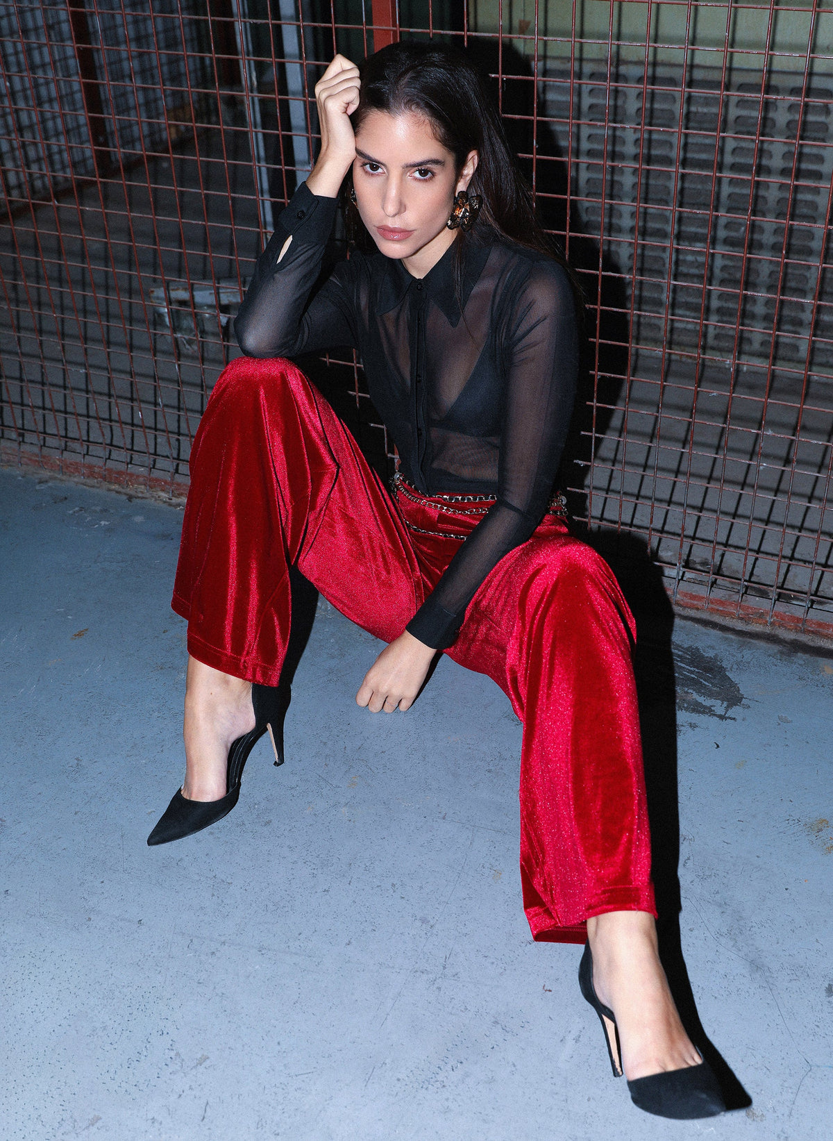 An'ge – Pantalon Pontalene Rouge, mannequin assise de face, chemise noire transparente et pantalon rouge velours