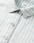 Détail d'une veste en denim léger rayé bleu ciel et écru, avec boutons métalliques gravés Labdip, tissu en coton structuré et coupe ajustée.
