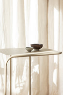 Beistelltisch DENYA mit minimalistischer Tischplatte und decorativen Schalen im Wohnzimmer.