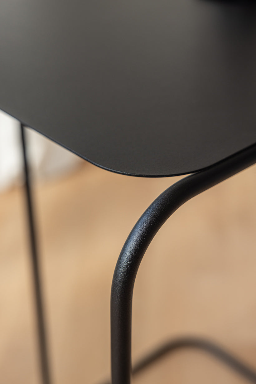 Detailaufnahme des eleganten Beistelltisch DENYA mit pulverbeschichtetem Metall und gebogenem Rundstahl.