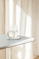 Beautiful DENYA mit Wasserglas auf Tischplatte im minimalistischen Design