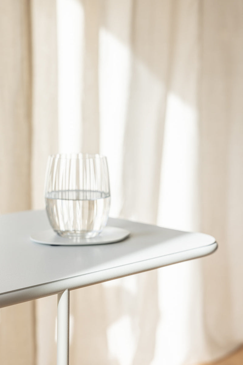 Beautiful DENYA mit Wasserglas auf Tischplatte im minimalistischen Design