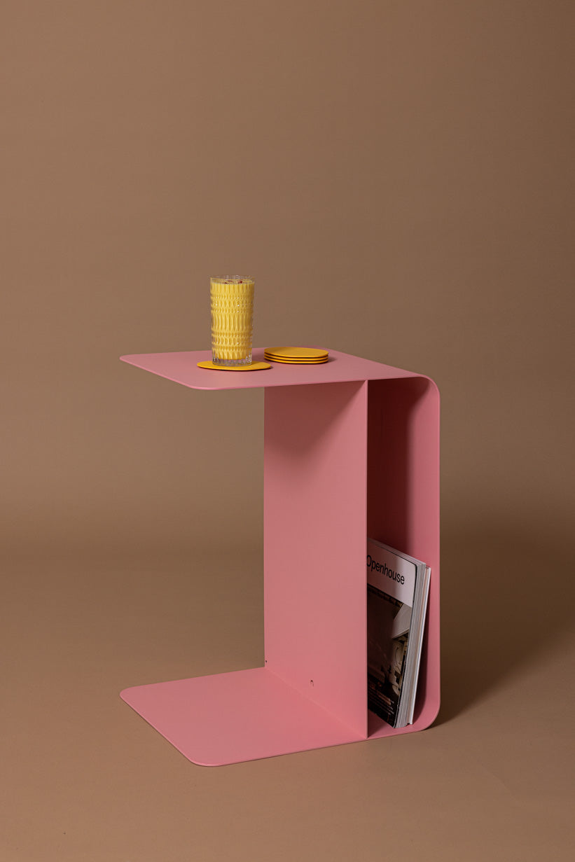 Beistelltisch COSMO in pink mit einem Glas und einer Zeitschrift, modernes minimalistisches Design.