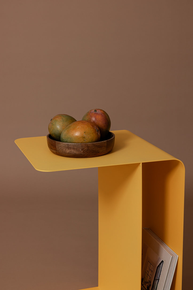 Beistelltisch COSMO in gelb mit Schale voller Mangos auf der Tischplatte.
