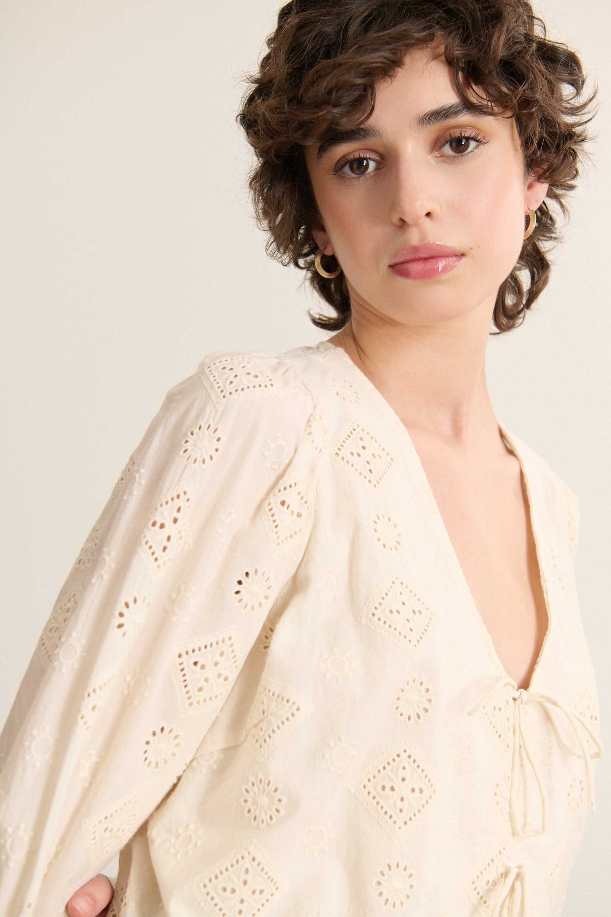 Blouse fabriquée entièrement en coton, coloris écru, fermeture à nœud et manches longues. 
