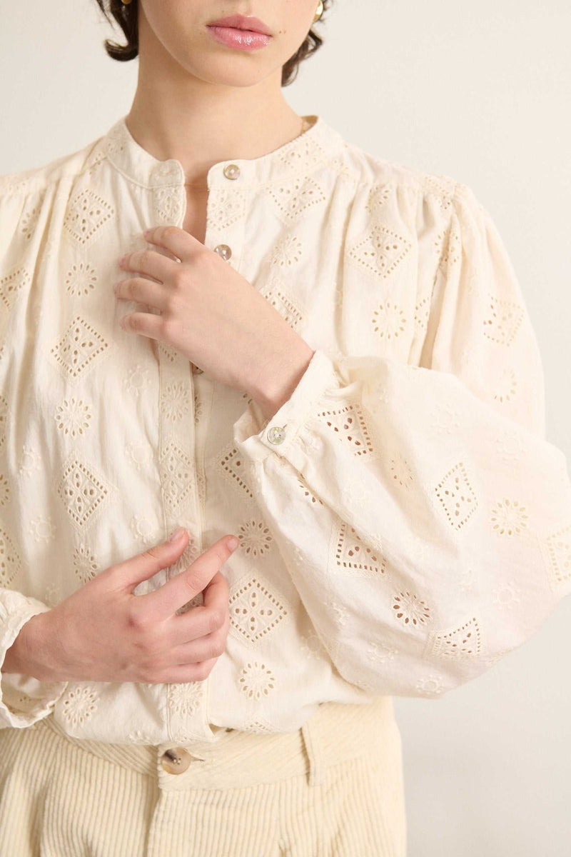 Tissu 100 % coton esprit broderie anglaise, ajouré sur toute la surface avec des motifs floraux brodés ton sur ton.