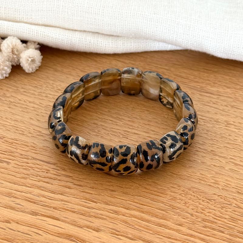 Instants Plaisirs – Bracelet Élastique "Alia" Résine, bracelet à motif léopard sur une surface en bois clair