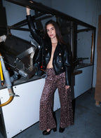 An'ge – Pantalon Perleo Noir, mannequin portant une veste en cuir noire et un pantalon imprimé léopard