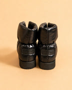 CAZABAT – Cazaboot - Boot In Black Nylon, Rückansicht zweier glänzender schwarzer Stiefel vor beigem Hintergrund