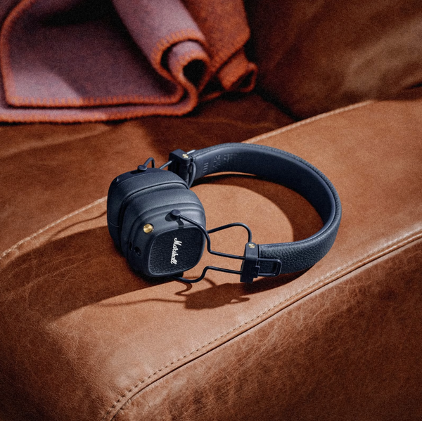 Marshall – Major V - Wireless Headphones - Midnight Blue, black headphones resting on a brown leather sofa