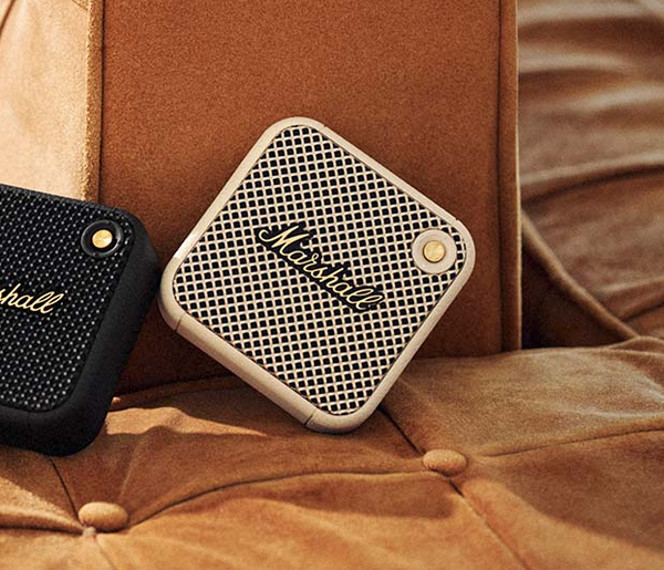Marshall – Willen II - Portable Speaker - Cream, two square portable speakers, one beige and one black, resting on a brown sofa