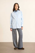 Mannequin femme de face portant une chemise ample bleu en coton, col classique, poche poitrine et coupe fluide. 