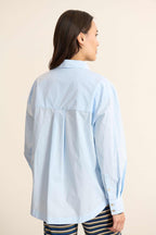 Vue arrière de la chemise ample, découpe horizontale haute avec fronces légères pour créer du volume au dos. 