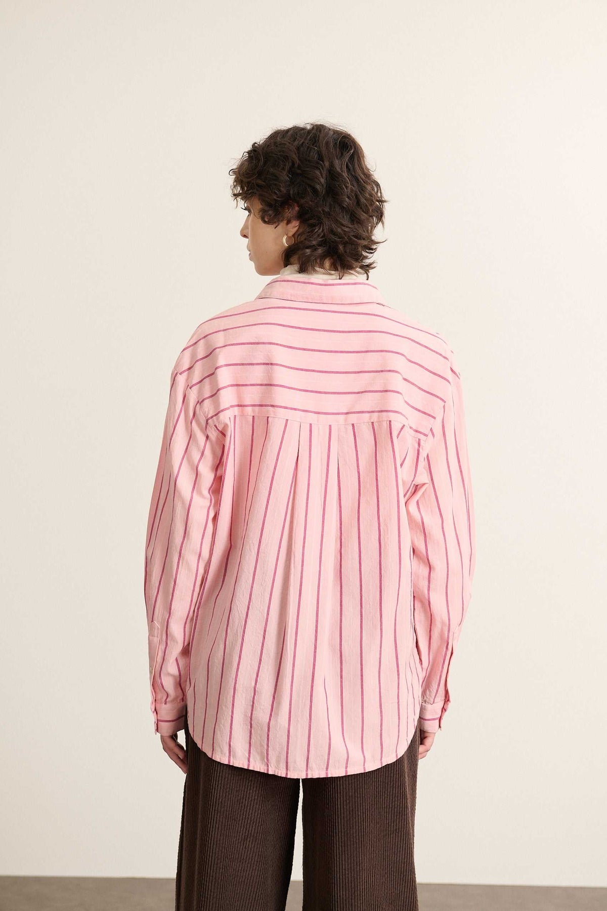 Vue arrière de la chemise ample rose, découpe haute dans le dos avec fronces réparties pour plus d'aisance. 