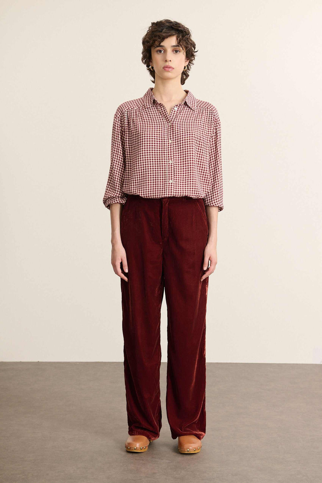 Mannequin femme de face portant une chemise en vichy bordeaux, coupe ample avec col chemise et fronces devant et de dos.
