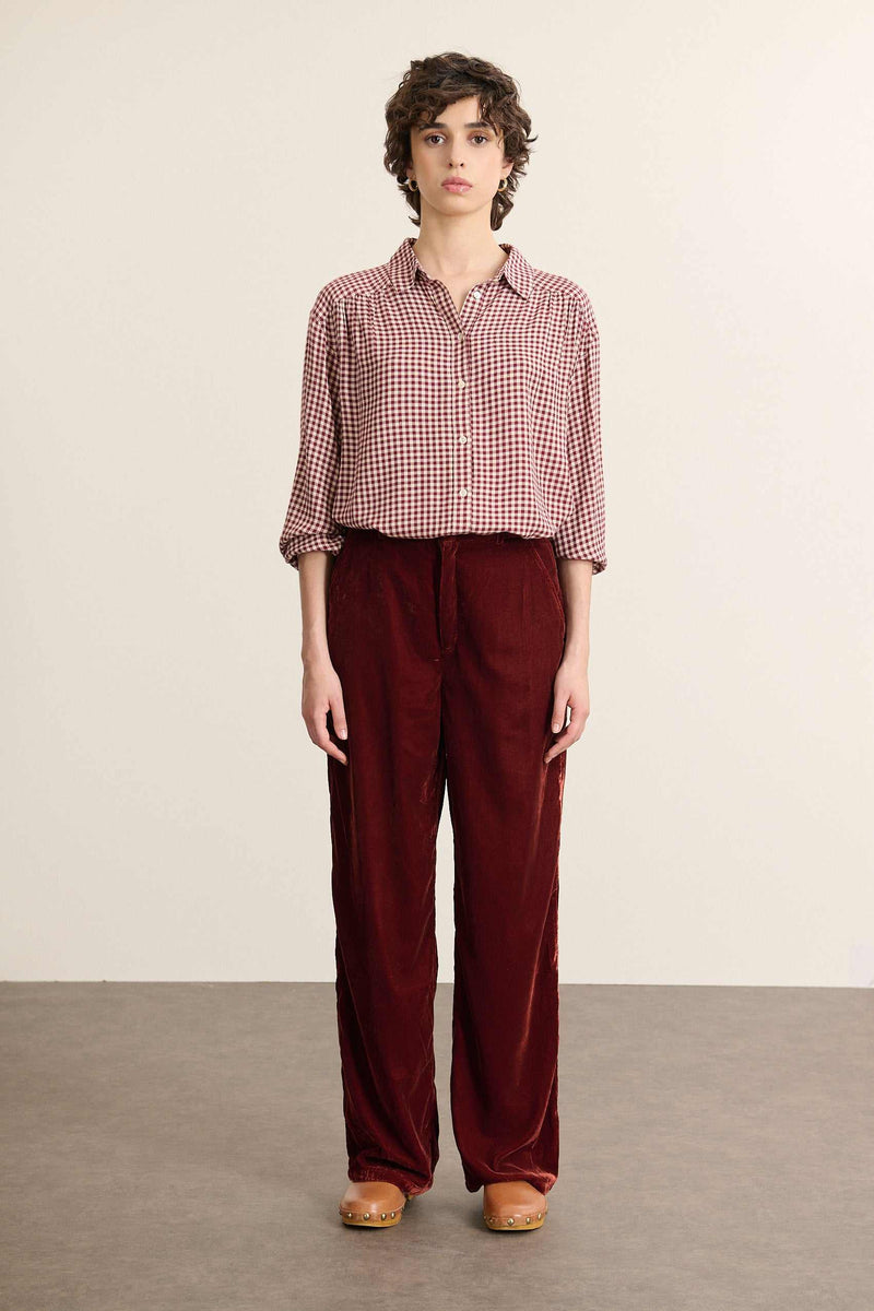 Mannequin femme de face portant une chemise en vichy bordeaux, coupe ample avec col chemise et fronces devant et de dos.