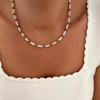 Instants Plaisirs – Collier "Emilie" Acier, collier de perles blanches et de perles dorées porté par une femme