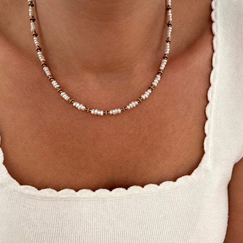 Instants Plaisirs – Collier "Emilie" Acier, collier de perles blanches et de perles dorées porté par une femme